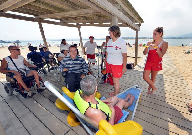 El servicio de baño adaptado para personas con movilidad reducida ya está en marcha en la Playa de los Peligros y estará atendido durante todo el verano por dos socorristas. / Alerta