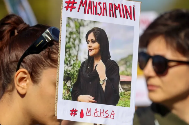 Una pancarta con la imagen de la joven de Irán Masha Amini. EFE / Julien Warnand