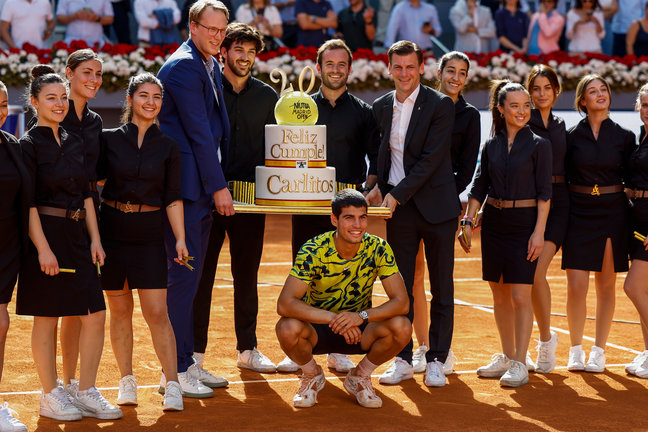 El tenista español Carlos Alcaraz junto a una tarta en la que se le desea feliz cumpleaños tras su partido ante el croata Borna Coric, de semifinales del Mutua Madrid Open de tenis, en la Caja Mágica, en Madrid. /Chema Moya
