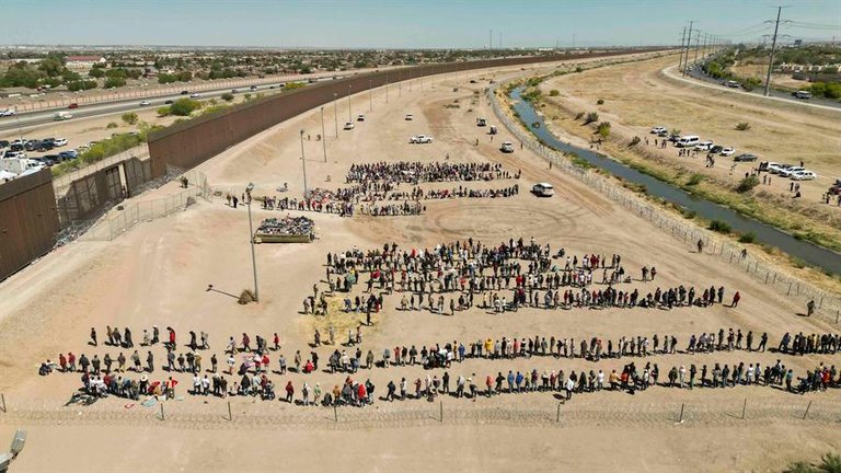 Imagen aérea en la que se registró a cientos de migrantes mientras esperan junto al muro fronterizo en El Paso (Texas, EE.UU.). EFE/Jonathan Fernández
