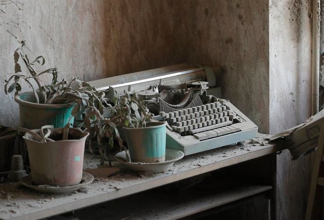 El polvo cubre una máquina de escribir y varias plantas marchitas en el interior de una vivienda de Kiev. EFE / Sergey Dolzhenko