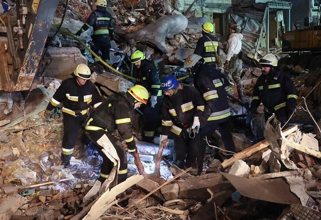 Un equipo de bomberos ucranianos buscando supervivientes entre las ruinas de un edificio alcanzado por un bombardeo ruso en la ciudad de Dnipro. EFE / SERGEY KOZLOV