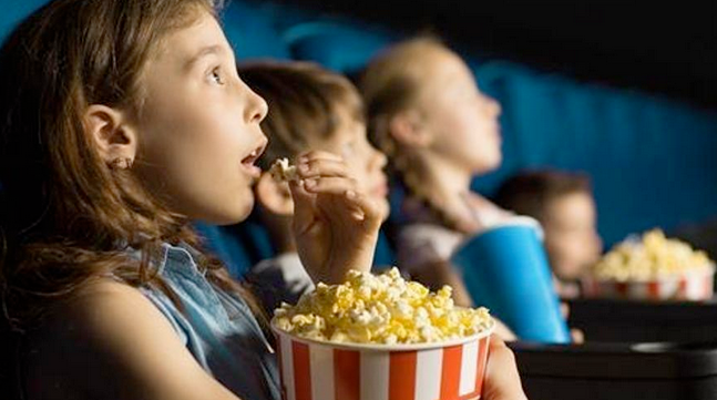 Niños comiendo palomitas en un cine. / EP