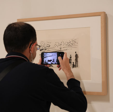 Un hombre fotografía con su teléfono móvil un dibujo de Picasso de la exposición. / Marta Fernández