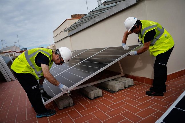 Operarios instalando placas solares en un edificio residencial de Barcelona. EFE / Enric Fontcuberta