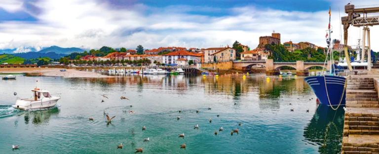 San Vicente de la barquera pueblo en Cantabria,España.pintoresco pueblo medieval ,paisaje panoramico de montana y mar en el norte de España.verdes prados y barcos en el puerto