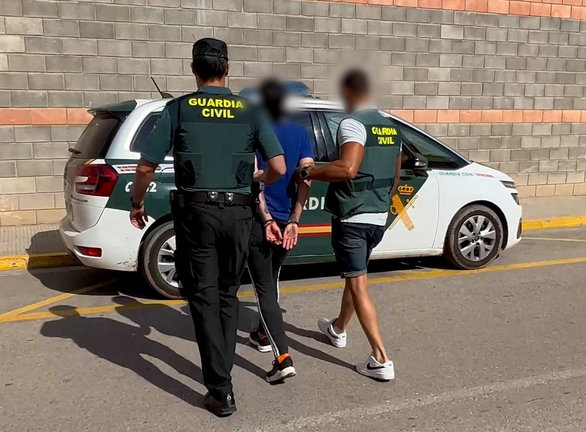 Dos agentes de la Guardia Civil conducen a un detenido. / ALERTA