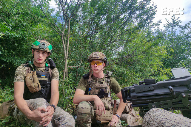Dos soldados ucranianos hacen guardia en una posición defensiva de la zona del frente de Kupiansk, en el noreste de Ucrania. EFE/ Marcel Gascón
