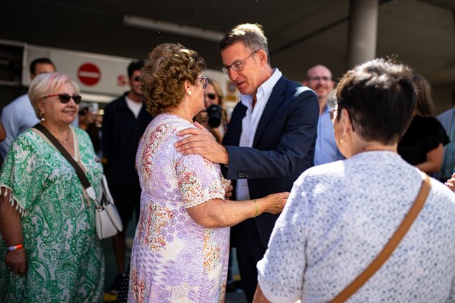 El líder del Partido Popular, Alberto Núñez Feijóo, junto a unas mujeres que le saludaban. / Elena Fernández