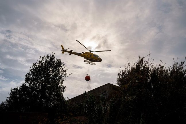 -Un helicópteros recarga agua en el municipio de El Sauzal para atajar un foco situado en El Ravelo. EFE / Ramón de la Rocha