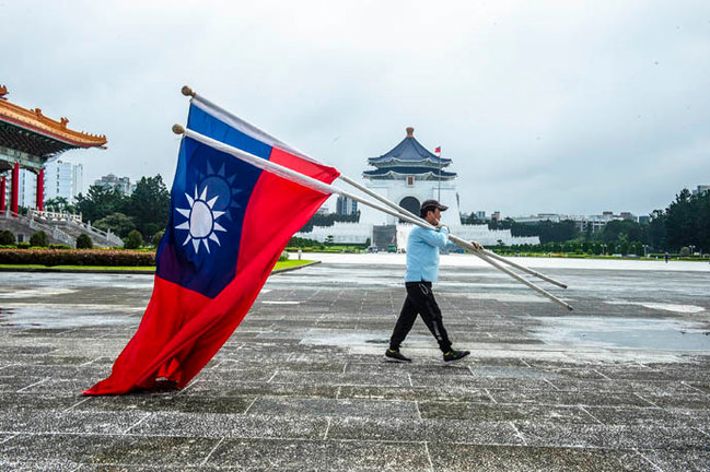 Un hombre porta banderas de la República de China en la Plaza de la Libertad. / e.p.