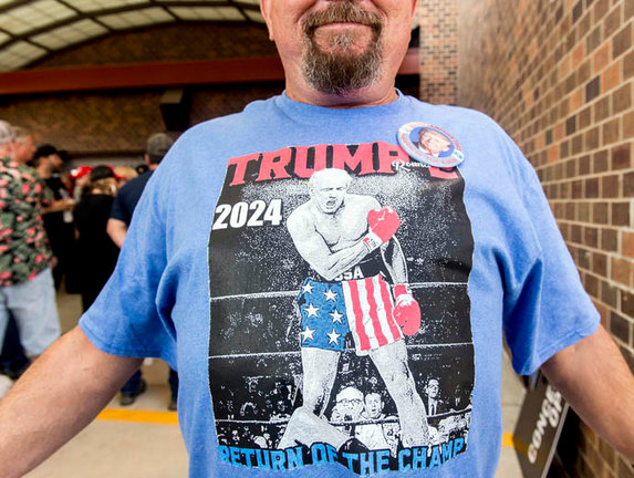 Un hombre exhibe una camiseta con un Trump victorioso. / aee