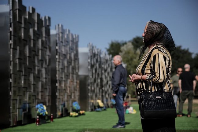 Visitantes del monumento para víctimas de crímenes de guerra, en Bucha, Ucrania. EFE / OLEG PETRASYUK