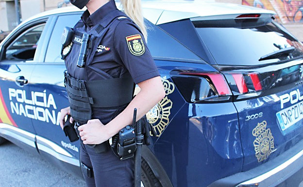 Una agente de la Policía Nacional junto a un coche de la patrulla. / AEP