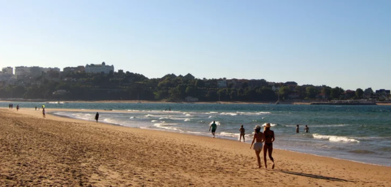 Gente paseando por la playa de Somo en una tarde soleada y ventosa Santander.