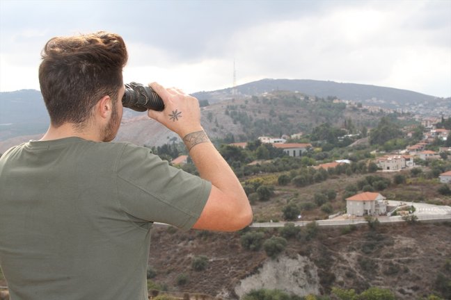Un hombre observa con unos binoculares la situación en la zona de Israel. EP / Taher Abu Hamdan