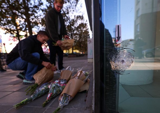 Personas ponen flores en el lugar en donde dos ciudadanos suecos fueron asesinados y un tercero resultó herido en el centro de Bruselas (Bélgica). EFE/EPA/OLIVIER HOSLET