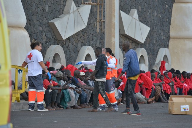 Trabajadores de la Cruz Roja al lado de los migrantes que han llegado en un cayuco a El Hierro. / EP