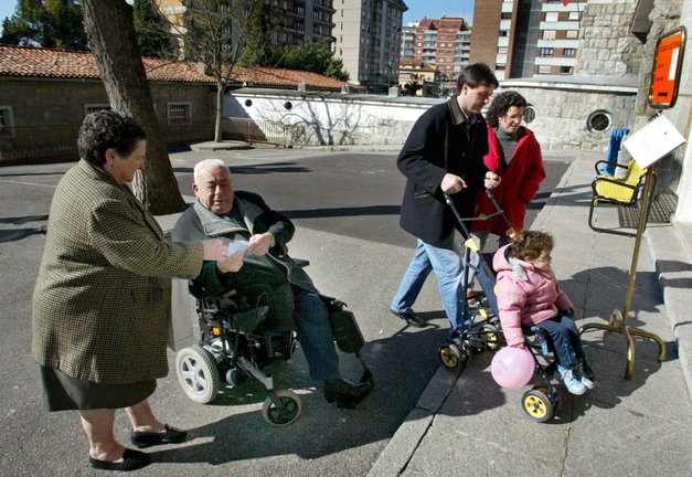 Un anciano discapacitado con su mujer y una pareja con un bebé. / Alberto Morante