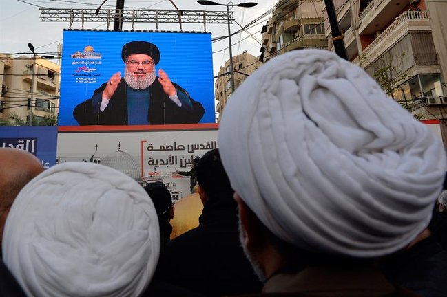Simpatizantes del grupo chií Hizbulá que observan una pantalla en la que aparece una imagen de su líder, Hasan Nasralá. / Wael Hamzeh