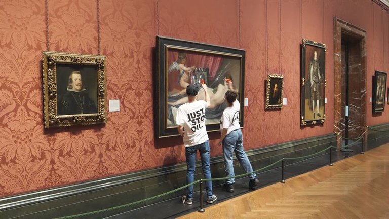 Dos ecologistas del grupo "Just Stop Oil" rompen el cristal que cubre la pintura "La Venus del espejo", pintada por Diego Velázquez en el siglo XVII, que se muestra en la National Gallery de Londres. / EFE
