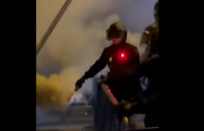 Un policía expulsando los gases para dispersar a los manifestantes.