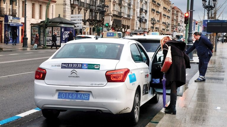 Dos personas cogen sendos taxis en la parada en Calvo Sotelo. / Alerta