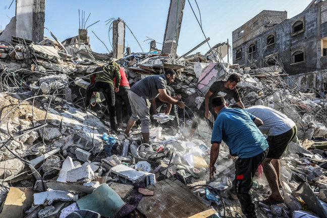 Un grupo de palestinos en una vivienda destruida por un ataque. / Abed Rahim Khatib