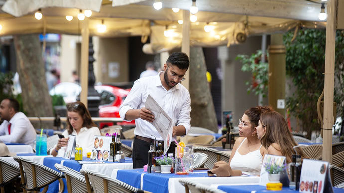 Un camarero atiende a una mesa en las Ramblas. / David Zorrakino
