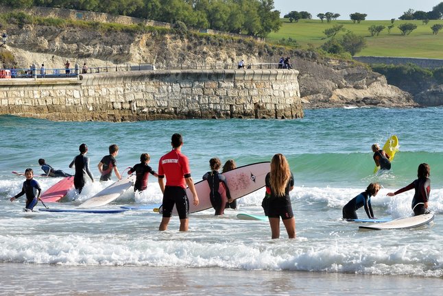 Jóvenes practicando surf en Santander. / Alerta