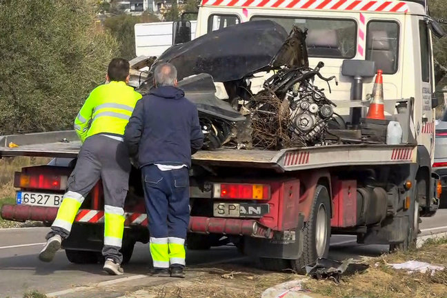 Una grúa se lleva restos de un vehículo en el que han fallecido tres personas, un adulto y dos adolescentes. / EFE