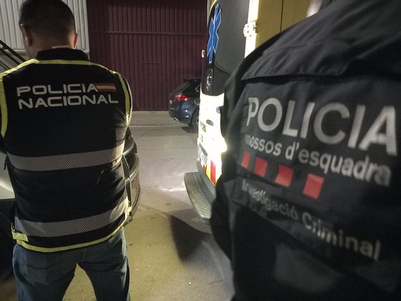 Agentes de la Policía Nacional y Mossos d'Esquadra de espaldas. / EP