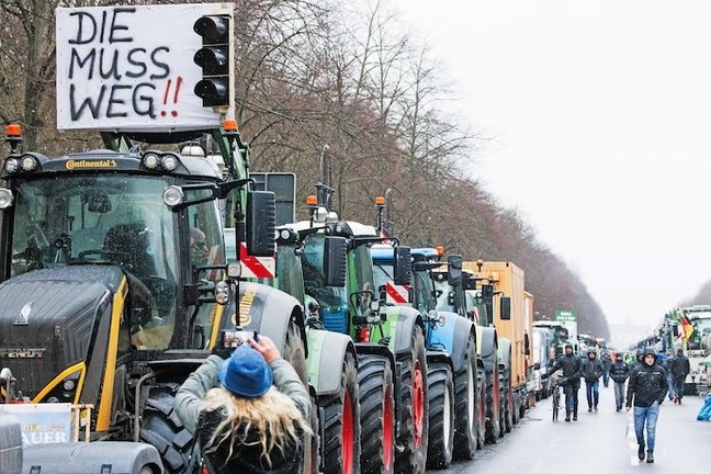 Berlin (Germany), 15/01/2024.- A tractor is decorated with a traffic-light and reading 'The 'Ampel' (so called traffic light coalition) has to go!' near the Brandenburg Gate during a nationwide farmers' strike in Berlin, Germany, 15 January 2024. Farmers went on a nationwide strike in Germany in protest against the federal government's agricultural policy. (Protestas, Alemania) EFE/EPA/CLEMENS BILAN