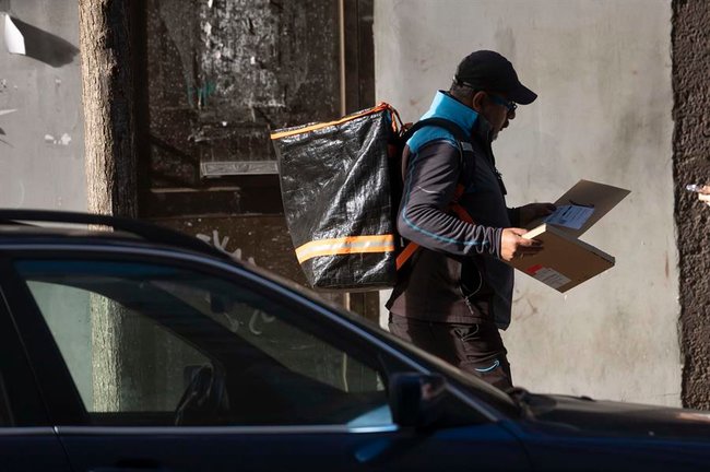 hombre reparte paquetes en una calle de Santander. EFE / Pedro Puente Hoyos