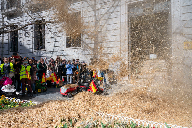 Varios agricultores tiran heno frente a delegación de Gobierno en Cantabria, durante la tractorada este viernes en Santander. / Pedro Puente Hoyos