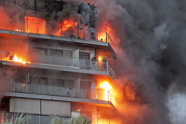 Dos personas aguardan en el balcón a ser rescatadas en el incendio declarado sobre las cinco y media de esta tarde en un quinto piso de un edificio de viviendas de València. / Manuel Bruque
