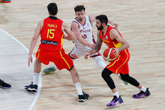 Ricky Rubio (d) bota el balón ante el base letón Kristers Zoriks (c) durante el encuentro clasificatorio del Eurobasket 2025. / EFE/ Javier Cebollada