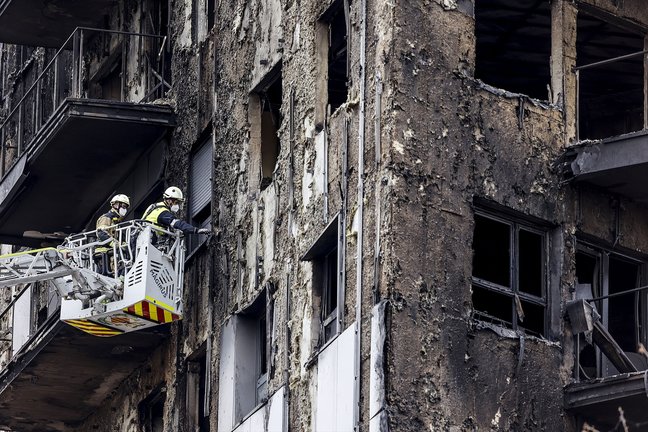 Bomberos en una grúa sanean la fachada quemada del edificio en Campanar. EP / Rober Solsona