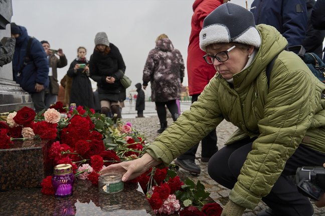 Una mujer enciende una vela por las víctimas de atentado terrorista en Rusia. EP / Guo Feizhou