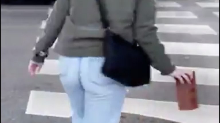 Una mujer cruza por un paso de peatones con un ladrillo. / Twitter