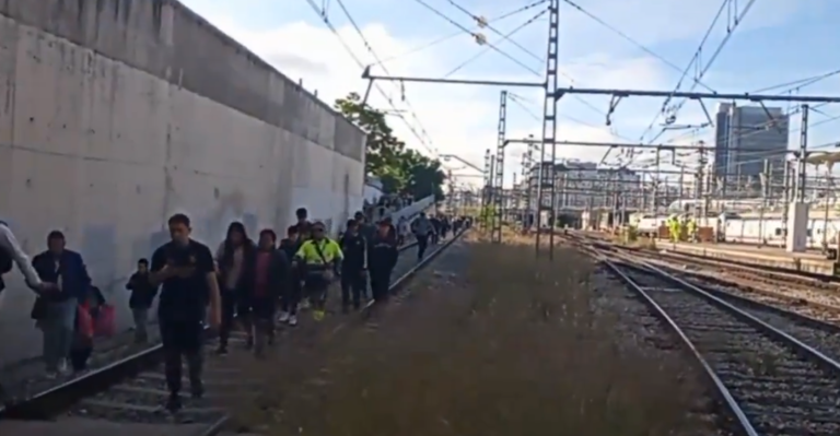 Los pasajeros caminando por las vías del tren tras el incidente con el tren de cercanías. / Captura de un vídeo