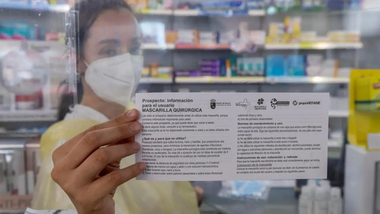 GRAFCVA4483 MURCIA, 
Una empleada de farmacia muestra el prospecto que informa de como usarlas mascarillas quir&uacute;rgicas que entregan a los pensionistas que retiran sus dos mascarillas gratuitas. Desde este lunes los mayores de 65 a&ntilde;os y pacientes vulnerables, unas 225.000 personas en toda la Comunidad de Murcia, podr&aacute;n recoger dos mascarillas gratuita en las casi 600 farmacias de la Regi&oacute;n de Murcia.EFE/Marcial Guill&eacute;n