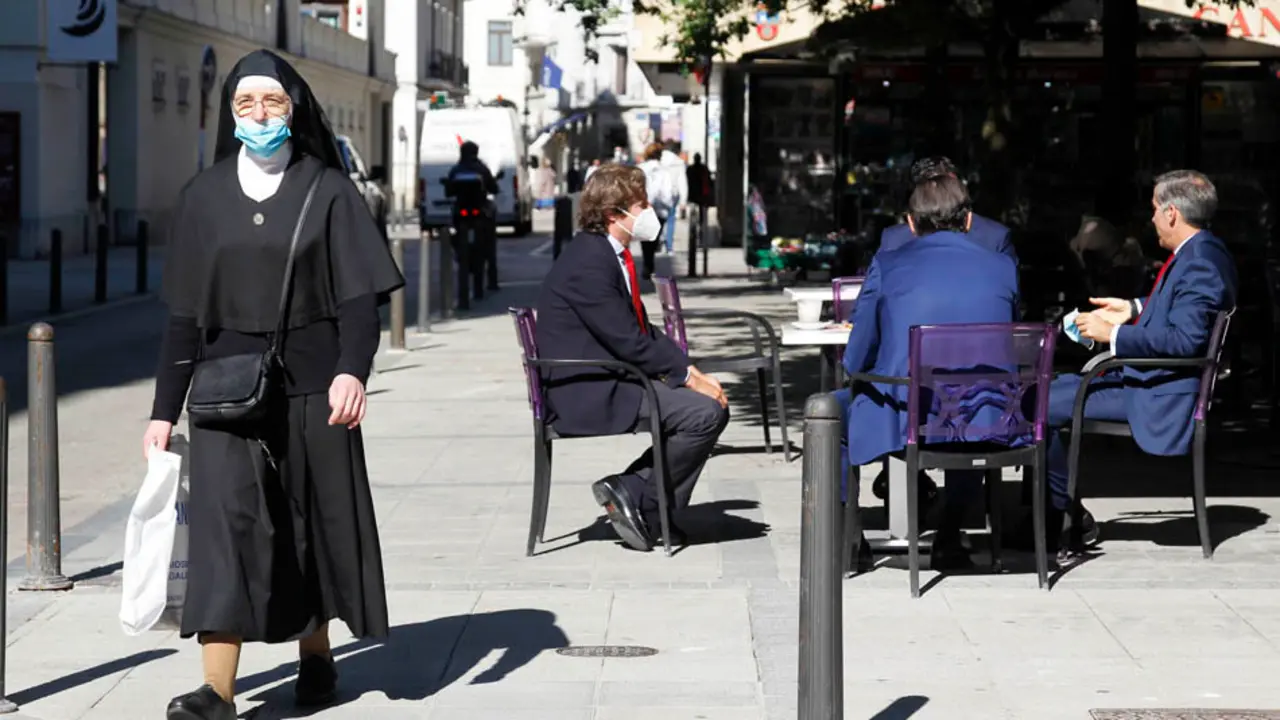 Una monja con mascarilla pasea por la calle Hern&aacute;n Cort&eacute;s de Santander.