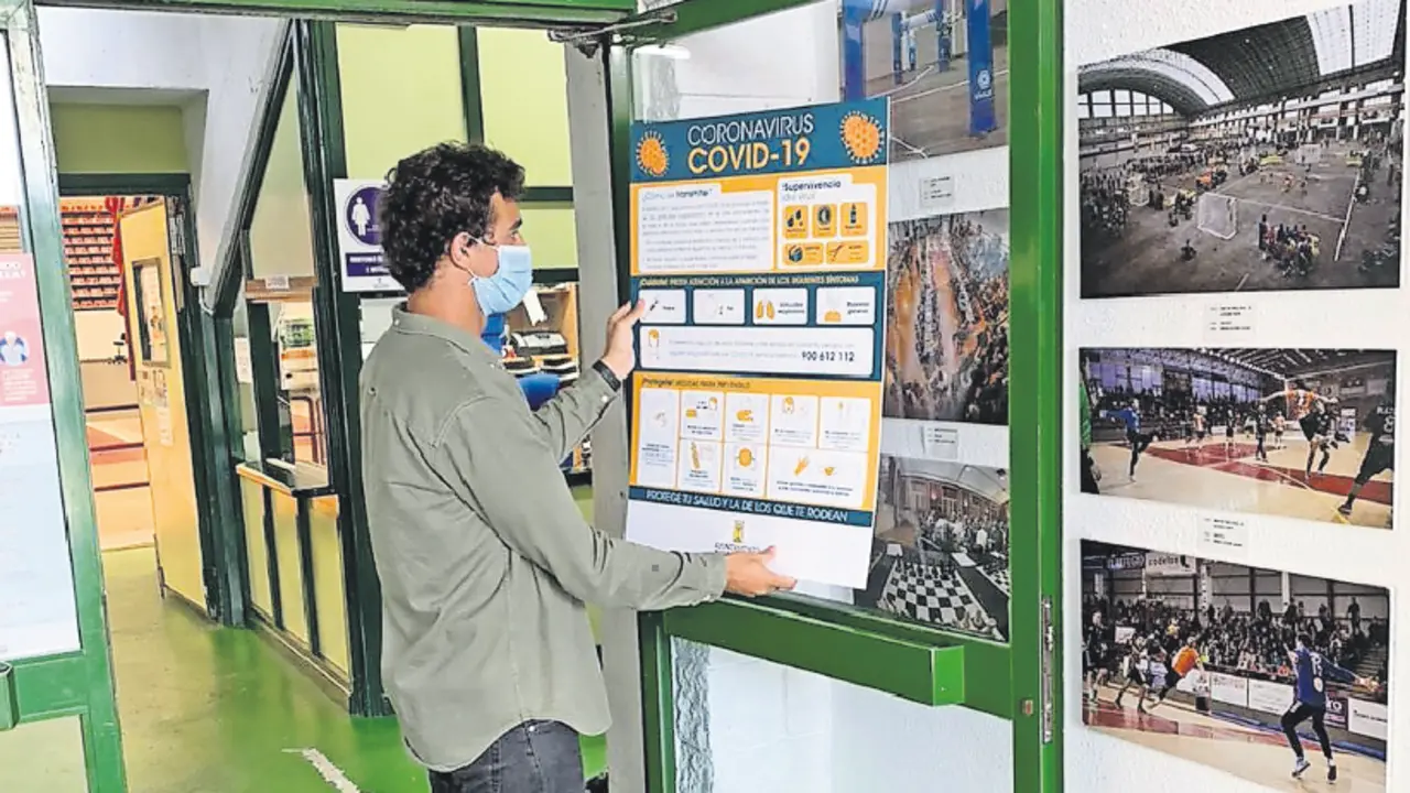 El concejal de Deportes, Ignacio Gonz&aacute;lez, colocando carteles sobre las medidas de protecci&oacute;n. / ALERTA
