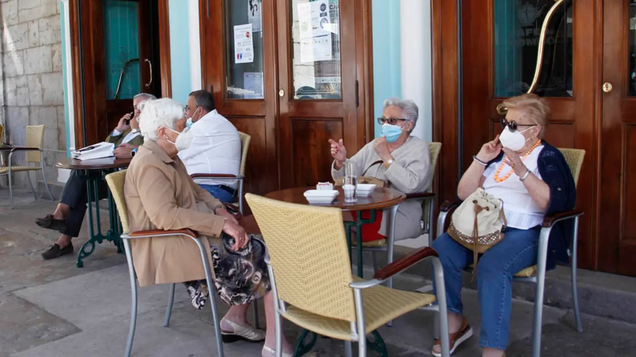 Varias personas disfrutan de la terraza en la plaza Pombo de Santander. / J. Ram&oacute;n