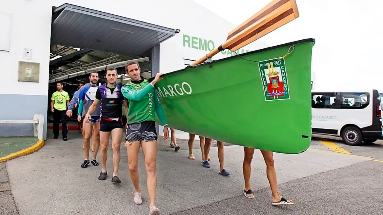 Gonzalo Solana, Javier Soler y David P&eacute;rez, con la trainera al hombro de Camargo. / j. r.