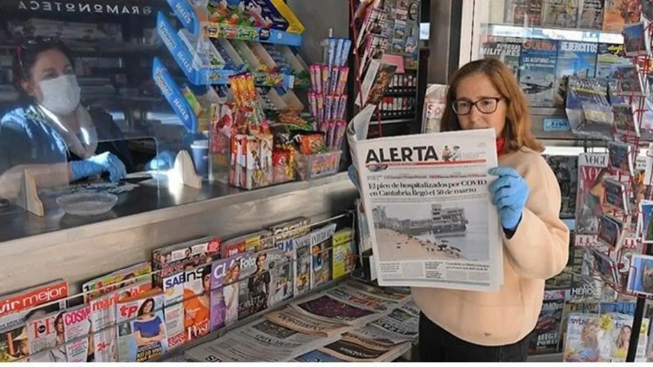 Una persona ojea un ejemplar de ALERTA en un kiosko de Santander. / Cubero / ARCHIVO