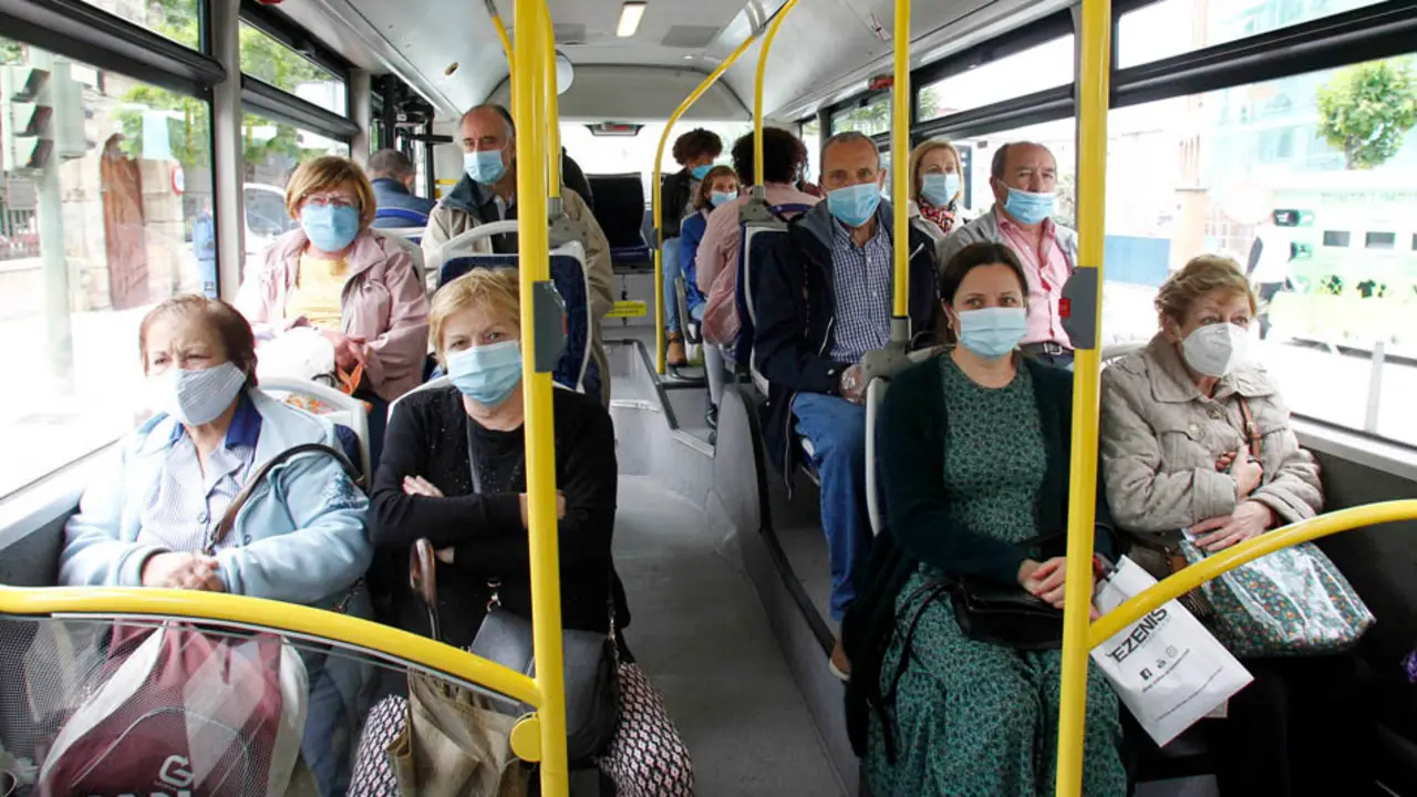 Varias personas con mascarilla sentadas en los asientos de un autob&uacute;s en Santander. / J. RAM&Oacute;N
