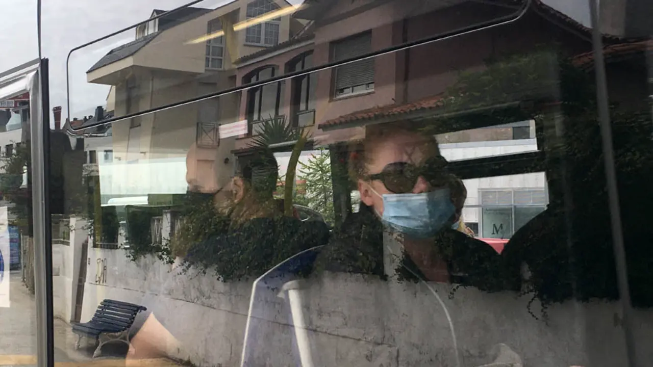 Dos personas sentadas en el autob&uacute;s de Santander con su respectiva mascarilla. / S.D.