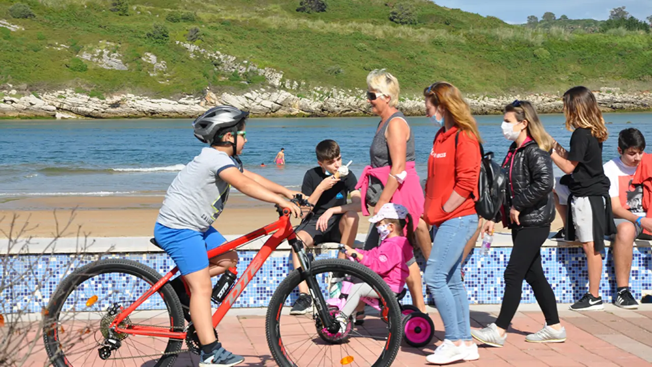 Varias personas disfrutan del d&iacute;a soleado en el pueblo costero de Suances, Cantabria. / S.D.